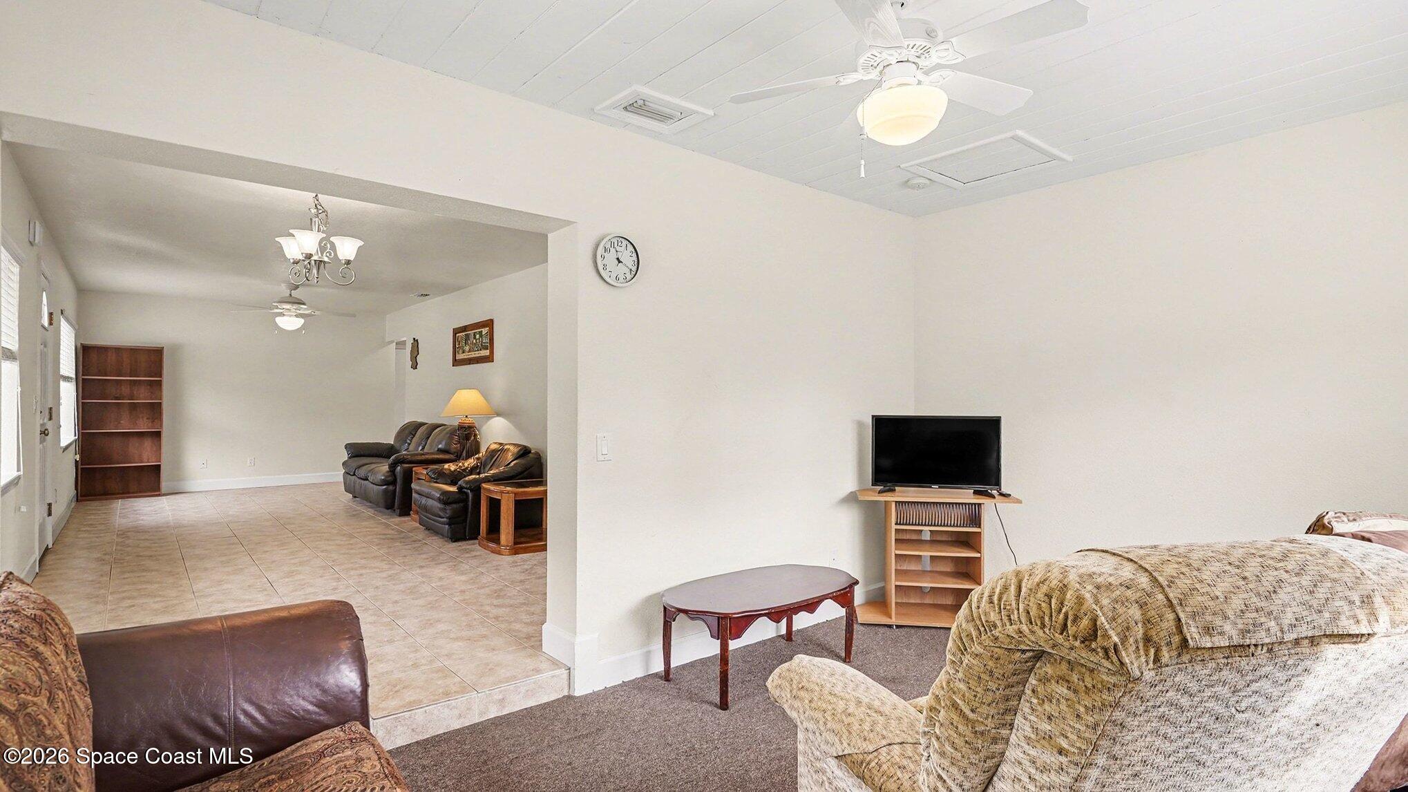 136 Gray Road Melbourne, FL 32904 - Photo 12 of 27 a living room with furniture a flat screen tv and a fireplace