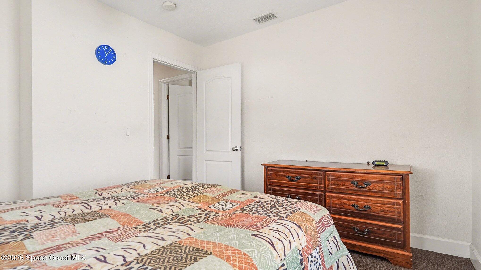 136 Gray Road Melbourne, FL 32904 - Photo 18 of 27 a bedroom with a bed and a dresser