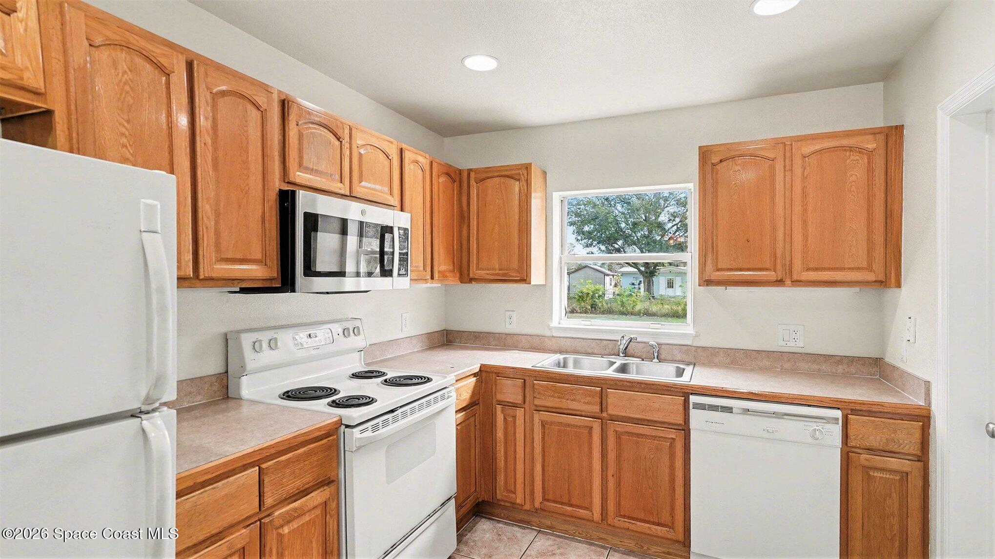 136 Gray Road Melbourne, FL 32904 - Photo 9 of 27 a kitchen with stainless steel appliances granite countertop a sink stove and refrigerator