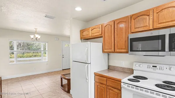 a kitchen with stainless steel appliances granite countertop a refrigerator a stove a sink and a microwave