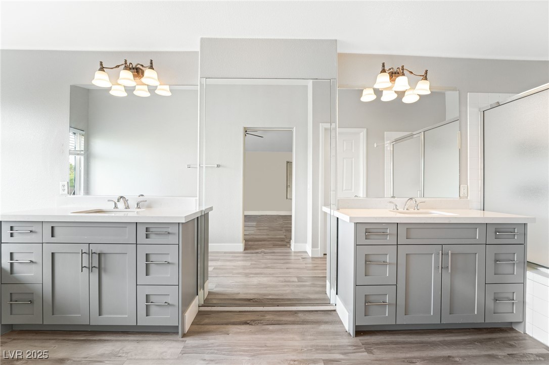 1533 Sabatini Drive Henderson, NV 89052 - Photo 22 of 27 Full bathroom featuring two vanities, a shower stall, and light wood-style flooring