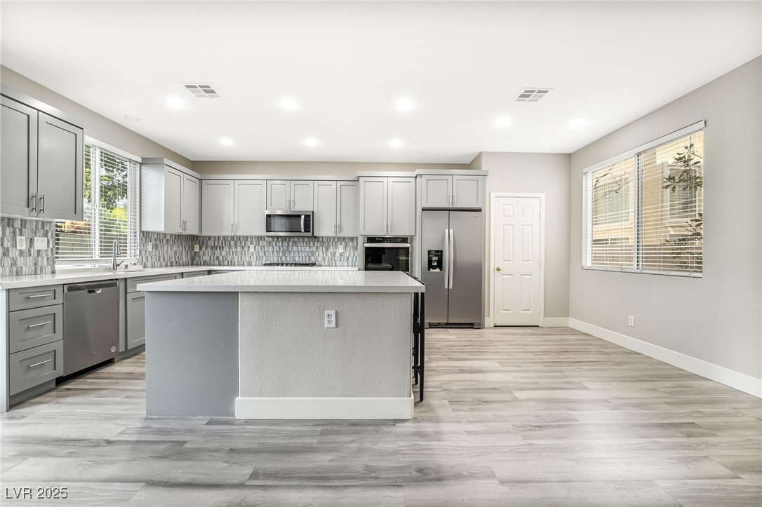 1533 Sabatini Drive Henderson, NV 89052 - Photo 7 of 27 Kitchen featuring gray cabinetry, appliances with stainless steel finishes, decorative backsplash, and recessed lighting
