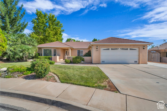 579 Spring Circle Washington, UT 84780 - Photo 1 of 1 Single story home featuring a tile roof, concrete driveway, an attached garage, stucco siding, and a front lawn