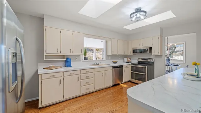 a kitchen with granite countertop a refrigerator stove top oven and sink
