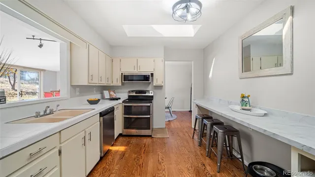 a kitchen with stainless steel appliances a stove sink microwave and cabinets