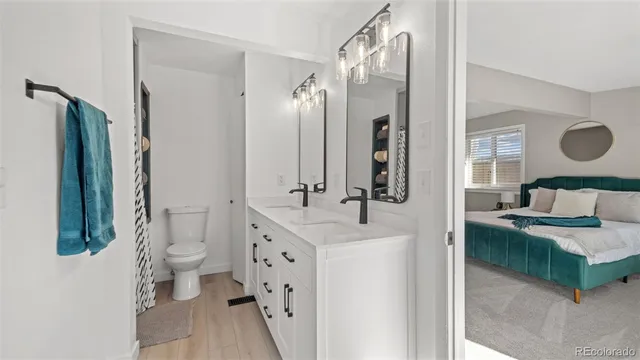 a en suite bathroom with a granite countertop sink and a mirror
