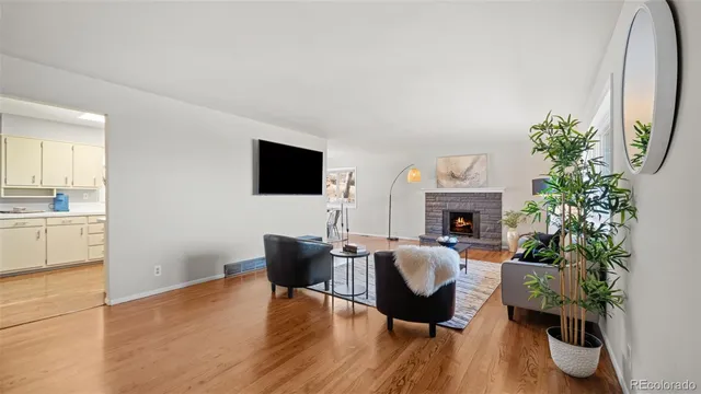 a living room with furniture a potted plant and a fireplace