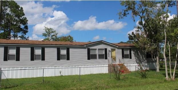 a view of house with a yard