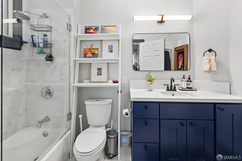 a bathroom with a toilet sink vanity tub and mirror