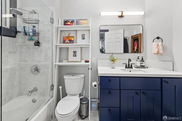 a bathroom with a toilet sink vanity tub and mirror