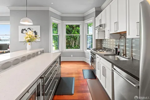 a large kitchen with stainless steel appliances granite countertop a lot of counter space and a window
