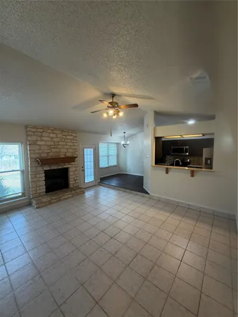 an empty room with windows and fireplace