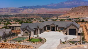 1141 East Lost Ridge Drive Washington, UT 84780 - Photo 19 of 108 Expansive property featuring a contemporary stucco and stone exterior, multi-car garage, concrete driveway, private tennis court, and desert landscaping with mountain scenery