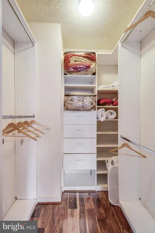 a view of walk in closet with clothes and shoes