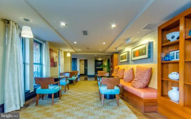 a living room with furniture kitchen view and a large window
