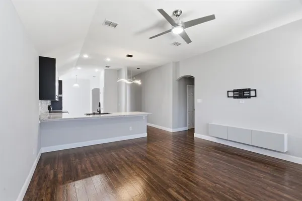 a view of a living room with wooden floor and a ceiling fan