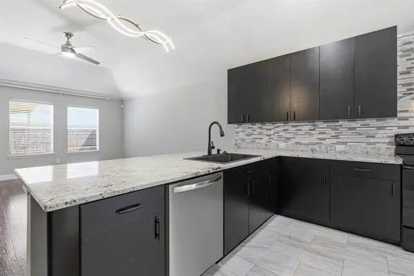 a kitchen with stainless steel appliances granite countertop a sink and a wooden cabinets