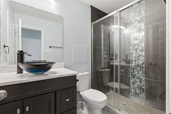 a bathroom with a sink a toilet and shower