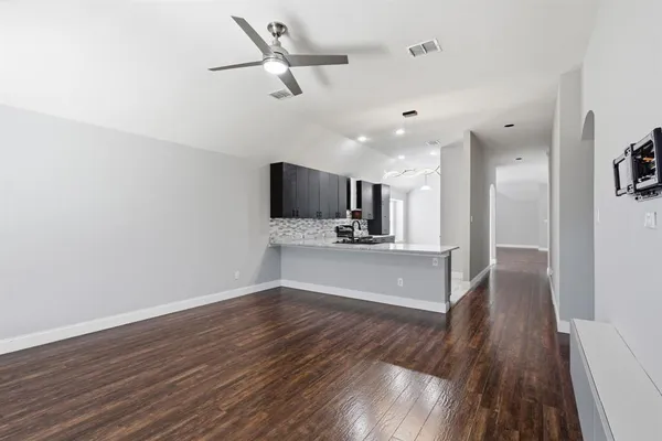 a view of a kitchen with wooden floor a sink and dishwasher