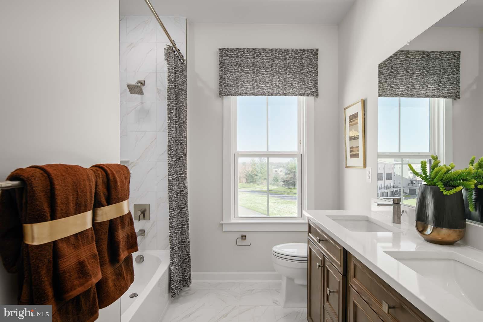 21799 Express Terrace, Unit 1122A Ashburn, VA 20147 - Photo 19 of 20 a bathroom with a granite countertop sink a mirror and a shower