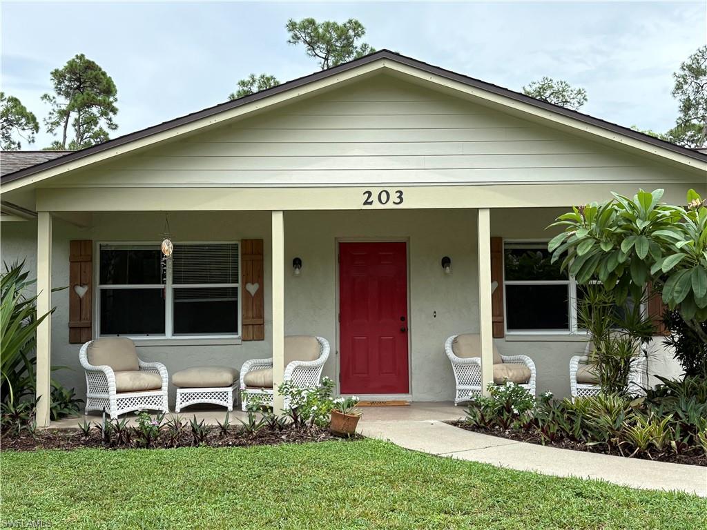 Bungalow-style house featuring a porch, a front lawn, and stucco siding