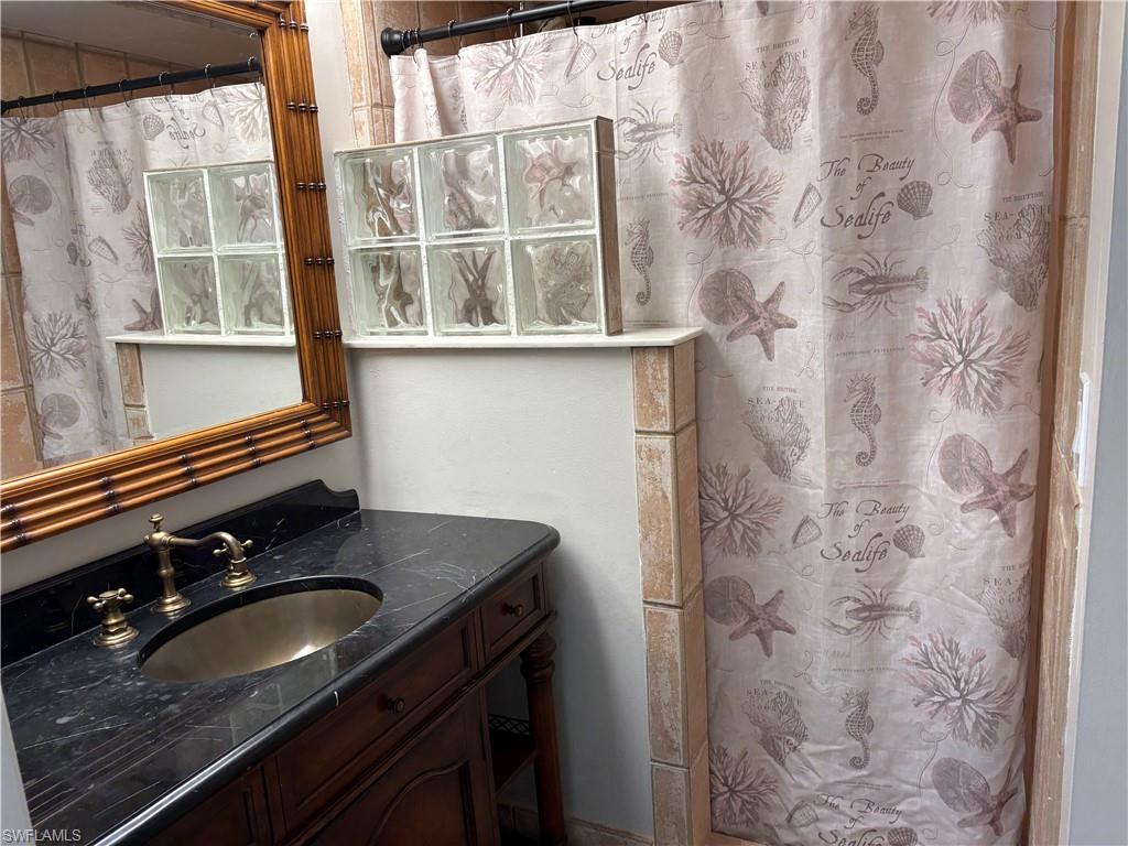 203 Esther Street Naples, FL 34104 - Photo 16 of 33 Bathroom with vanity and curtained shower