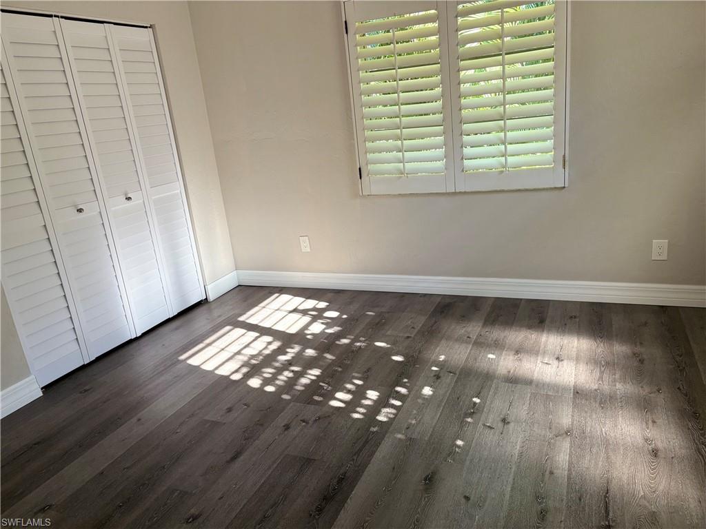 203 Esther Street Naples, FL 34104 - Photo 17 of 33 Unfurnished bedroom with a closet and dark wood-type flooring
