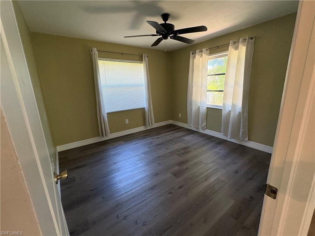 203 Esther Street Naples, FL 34104 - Photo 18 of 33 Empty room with dark wood-style floors and ceiling fan
