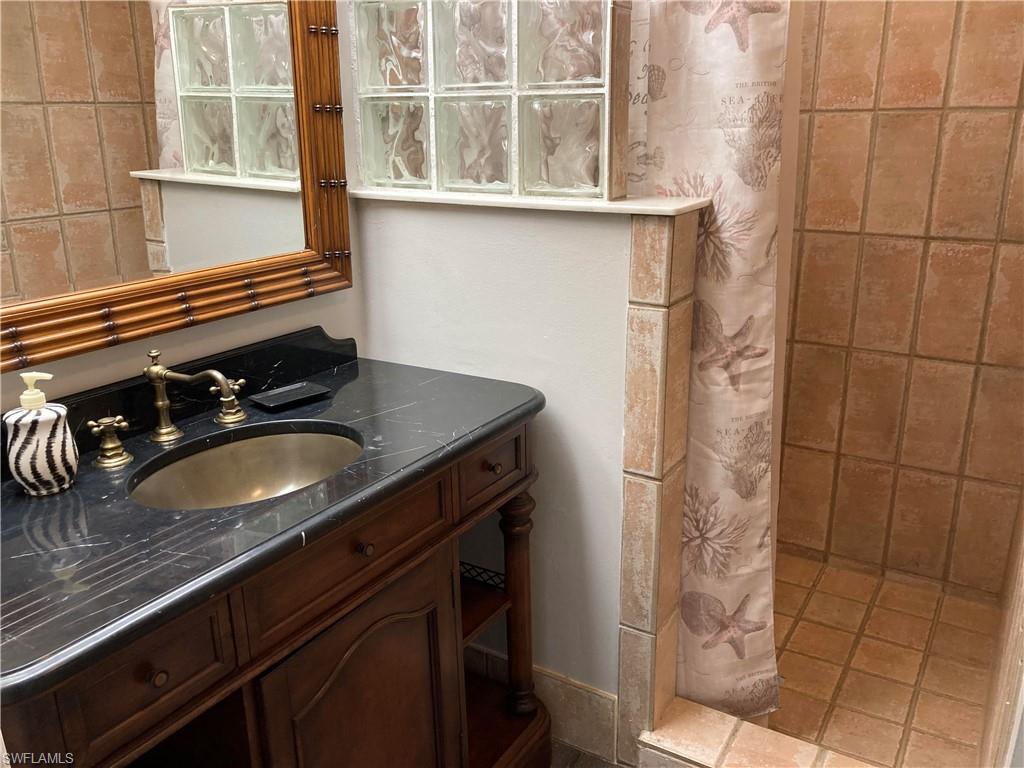 203 Esther Street Naples, FL 34104 - Photo 5 of 33 Bathroom featuring vanity and a tile shower