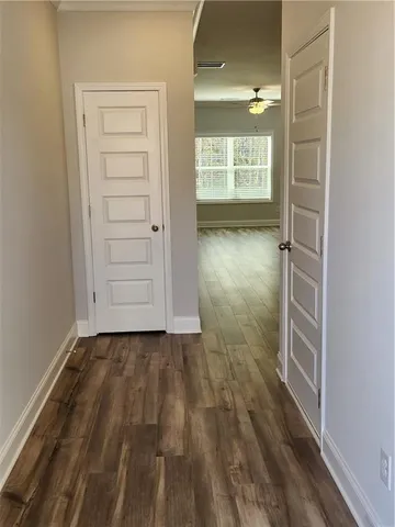 an empty room with wooden floor cabinet and windows
