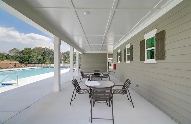 a dining room with furniture and a floor to ceiling window