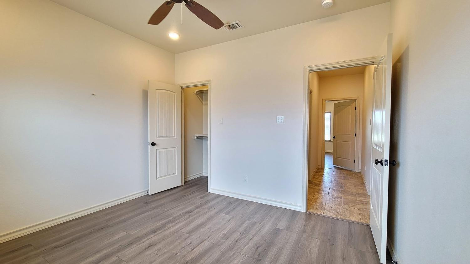 5234 Kemper Street Lubbock, TX 79416 - Photo 23 of 28 an empty room with wooden floor and a ceiling fan