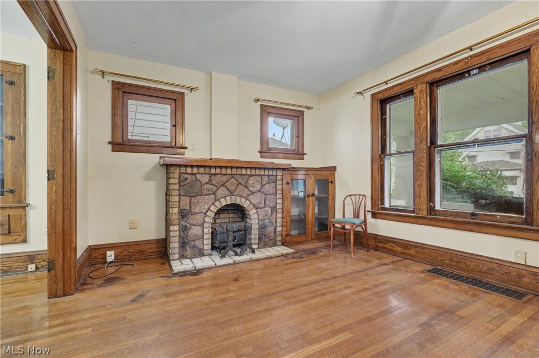456 Delmar Avenue Akron, OH 44310 - Photo 7 of 27 Living space featuring wood-finish flooring and a stone-clad fireplace with a brick firebox
