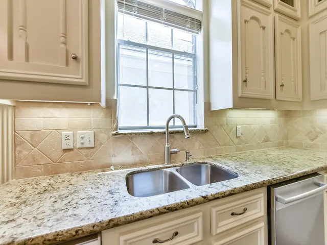 a kitchen with granite countertop a sink and a window