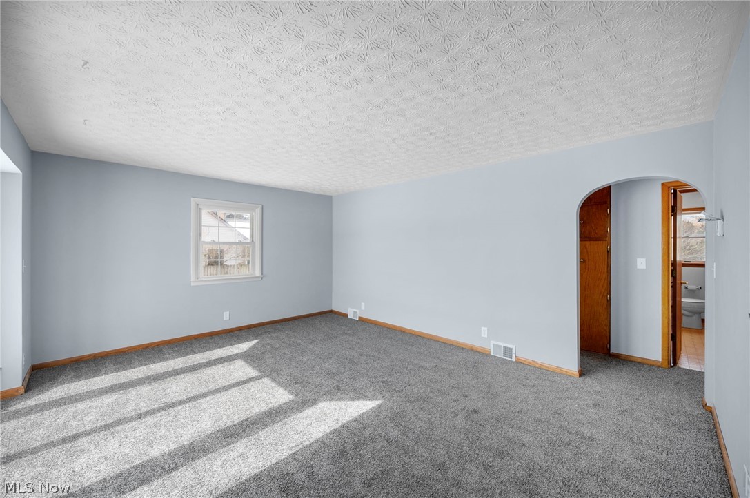 2099 Pontius Road Mogadore, OH 44260 - Photo 4 of 35 Carpeted spare room with arched walkways and a textured ceiling