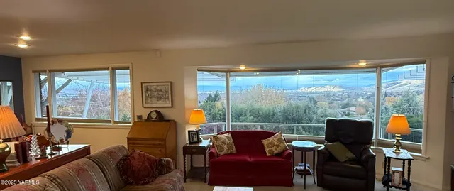 a living room with furniture and floor to ceiling windows