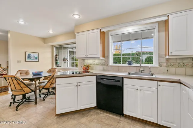 a kitchen with a sink dining table and chairs
