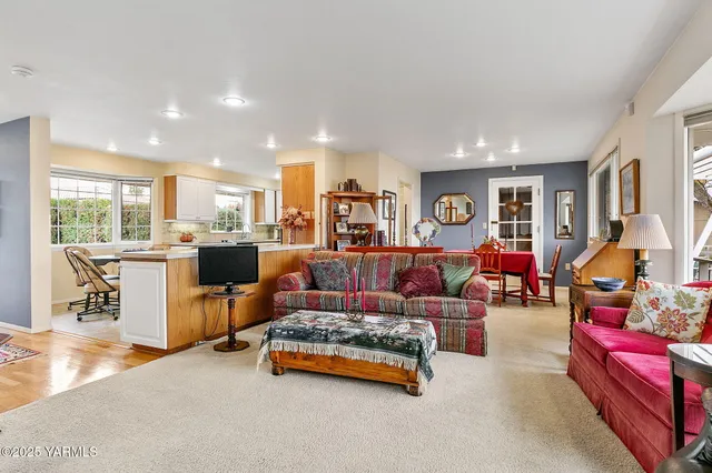 a living room with furniture and a dining table with kitchen view