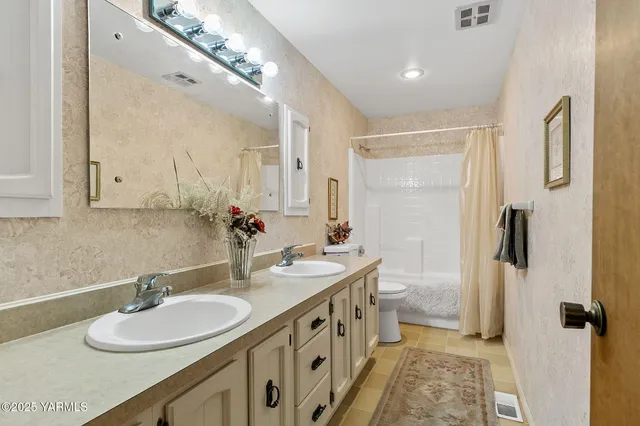 a bathroom with a double vanity sink and a mirror