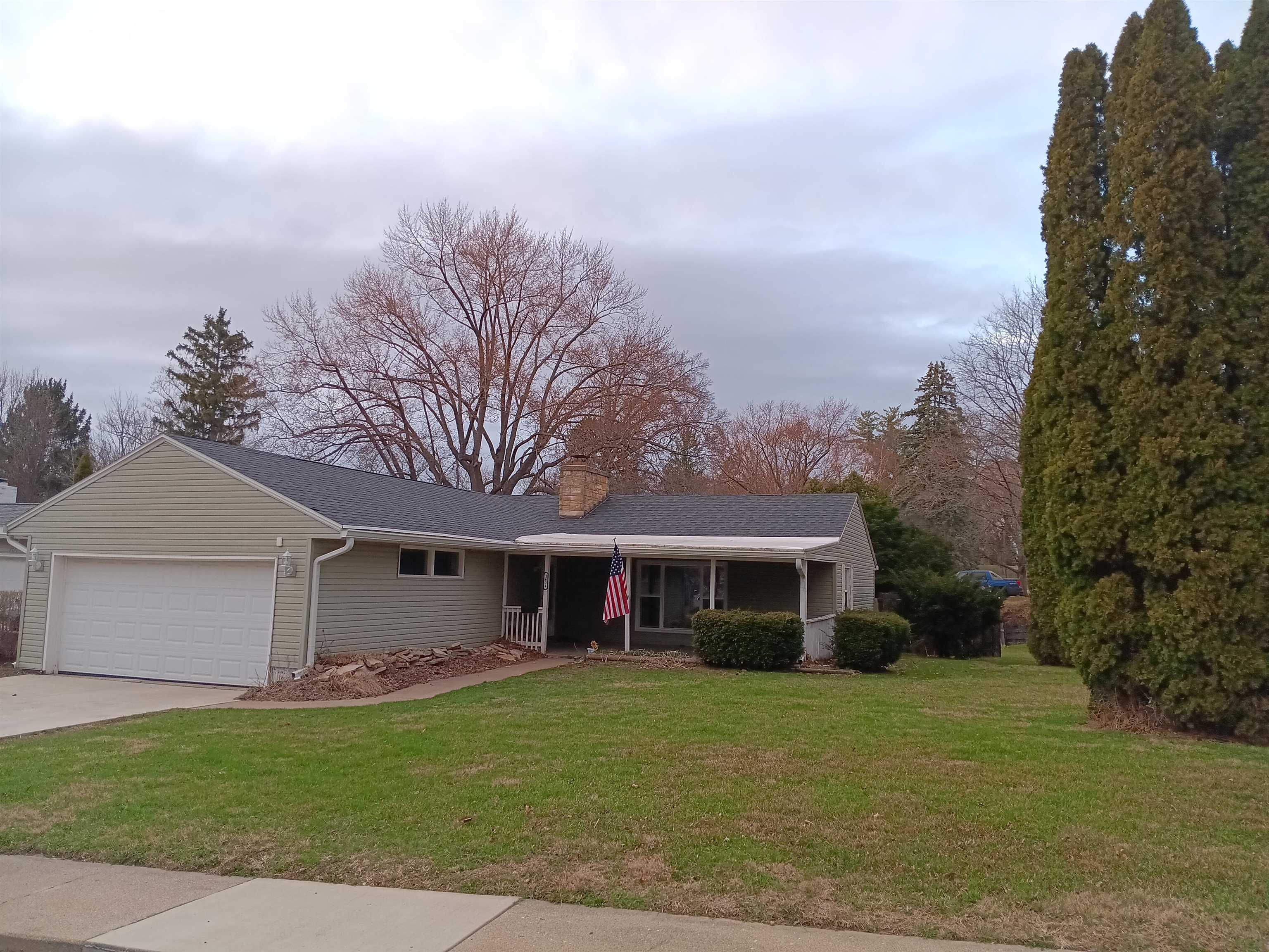 a view of a yard in front of a house with a large tree