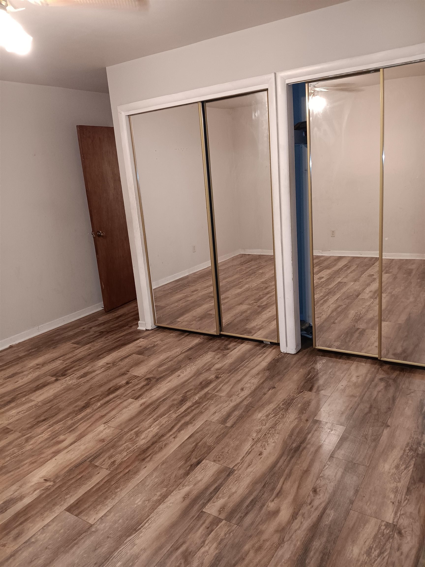 1604 Parkside Court Freeport, IL 61032 - Photo 8 of 11 an empty room with wooden floor and mirror