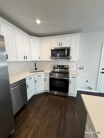 a kitchen with stainless steel appliances a stove a sink and a microwave
