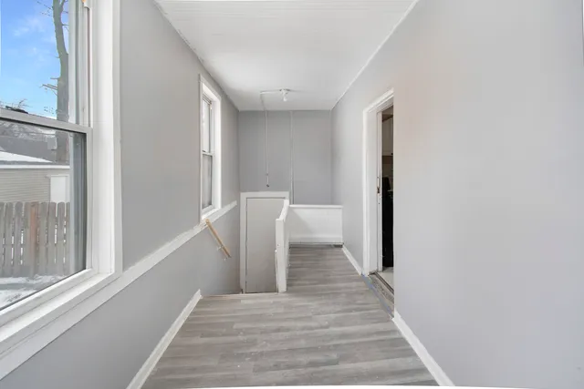 a view of a hallway with wooden floor and staircase