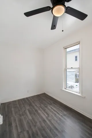 an empty room with a window and a fan