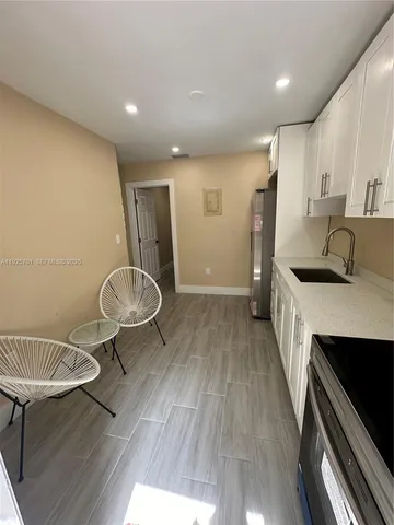 a kitchen with granite countertop a sink appliances and cabinets