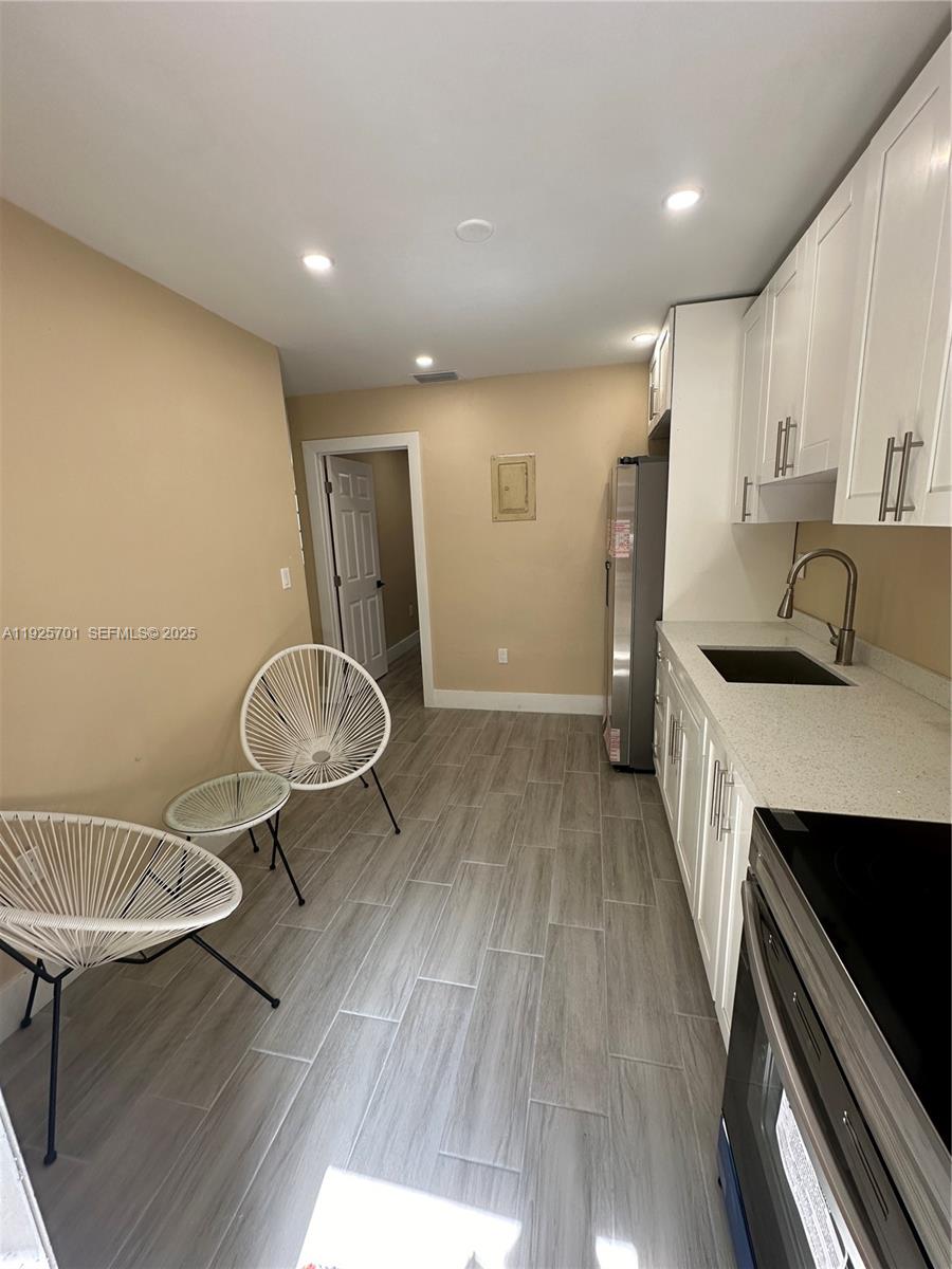 234 Northeast 55th Terrace Miami, FL 33137 - Photo 11 of 22 a kitchen with granite countertop a sink appliances and cabinets