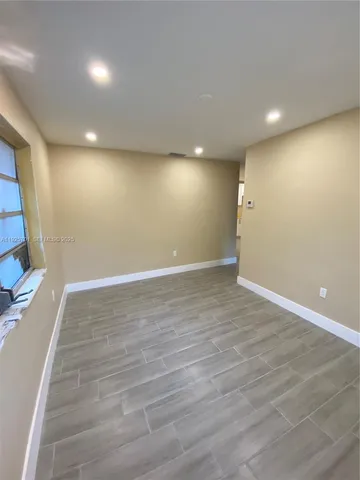 an empty room with wooden floor and entrance