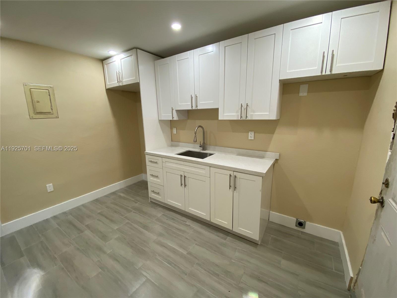 234 Northeast 55th Terrace Miami, FL 33137 - Photo 2 of 22 a view of a kitchen with white cabinets and wooden floor