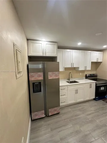 a kitchen with stainless steel appliances granite countertop a refrigerator a sink and a stove