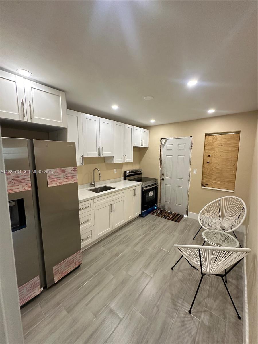 234 Northeast 55th Terrace Miami, FL 33137 - Photo 7 of 22 a kitchen with stainless steel appliances granite countertop a refrigerator sink and cabinets